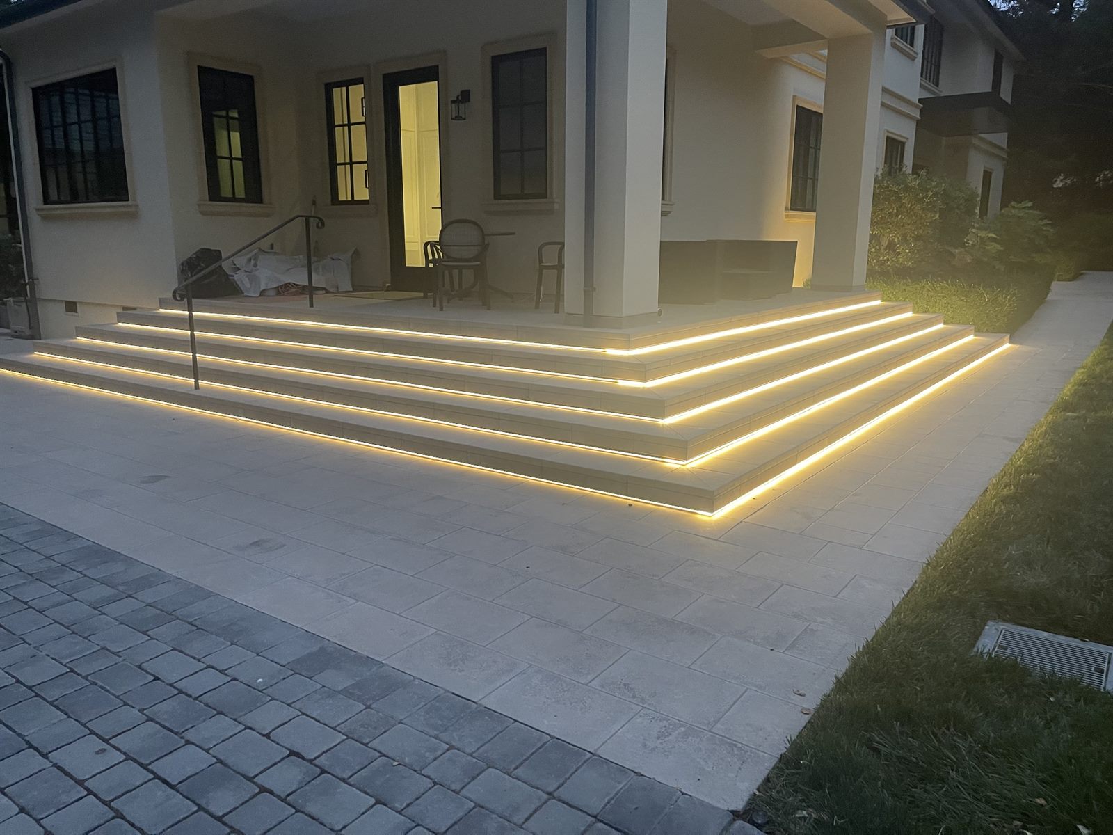 LED step lighting at a luxury home entry, dusk